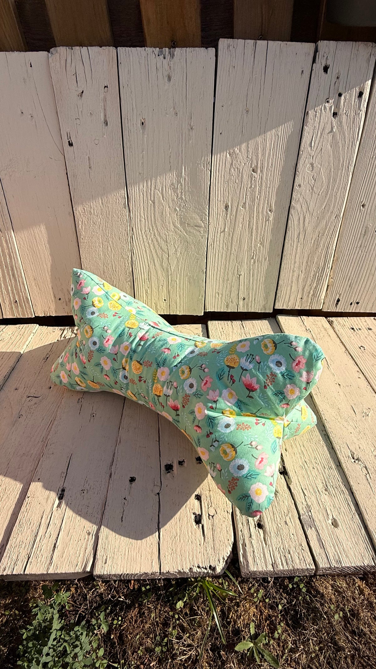 Handgefertigter Leseknochen als Nackenkissen, hellgrüner Baumwollstoff mit buntem Blumen- und Blütenmuster, gemütliches Kuschelkissen aus Dein Krämerladen."
