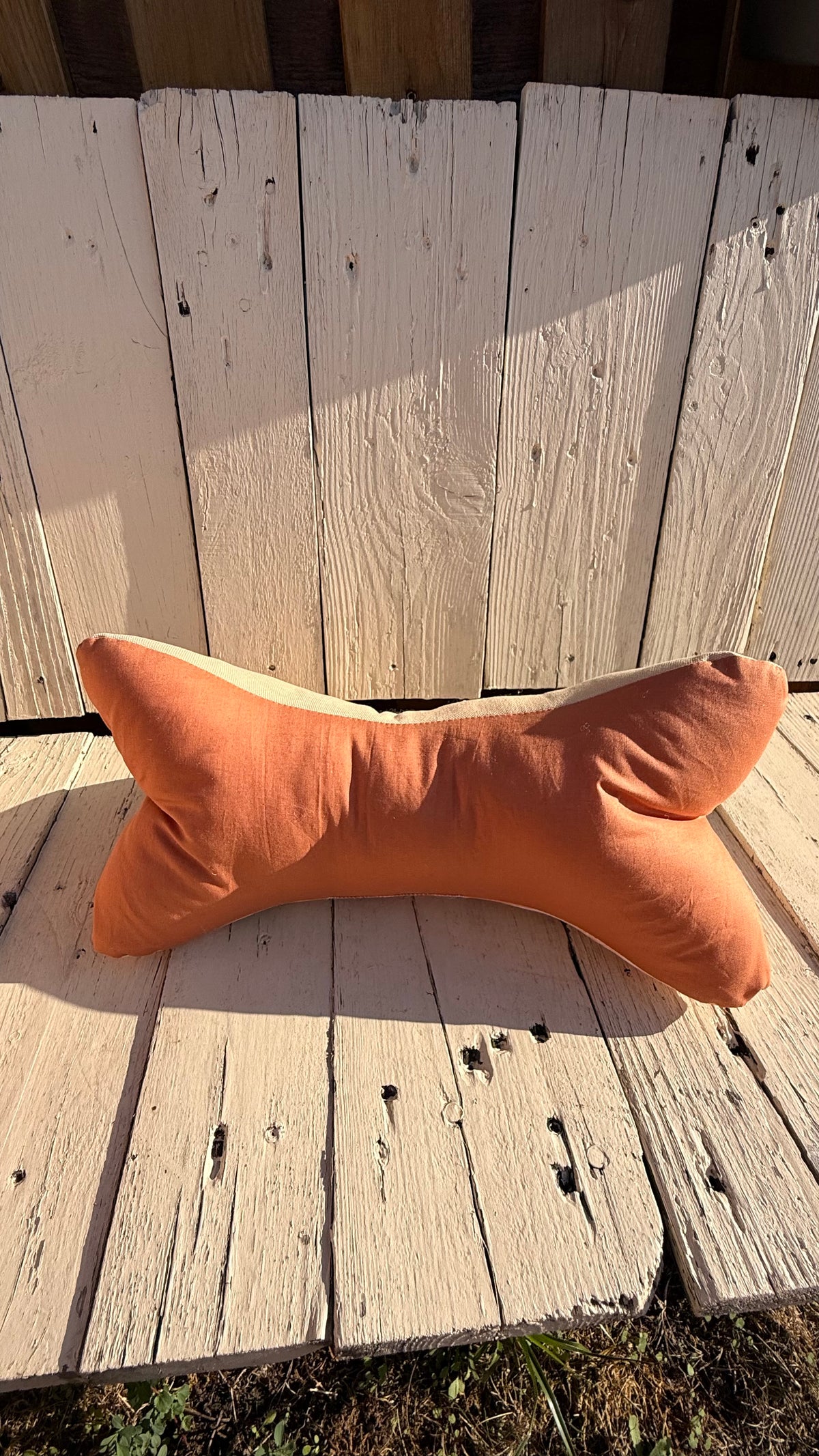 Handgefertigter Leseknochen als Nackenkissen, heller Stoff mit zarten peach- und korallfarbenen Blumen und Blättern, kombiniert mit einfarbig terracottafarbenem Stoff, aus Dein Krämerladen.