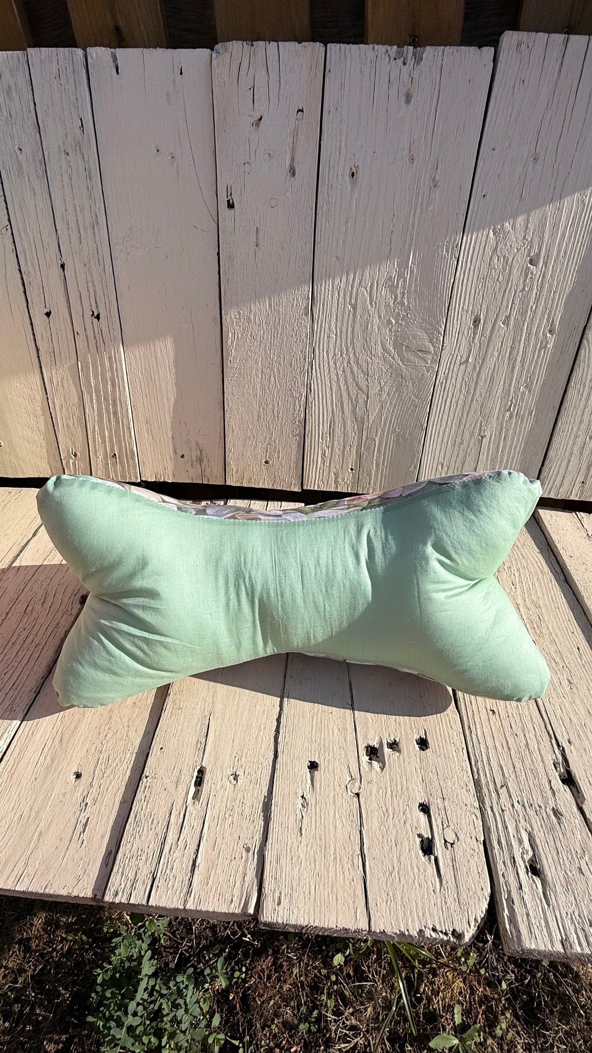 Handgefertigter Leseknochen als Nackenkissen, hellgrüner Baumwollstoff mit buntem Sukkulentenmuster, gemütliches Kuschelkissen aus Dein Krämerladen."