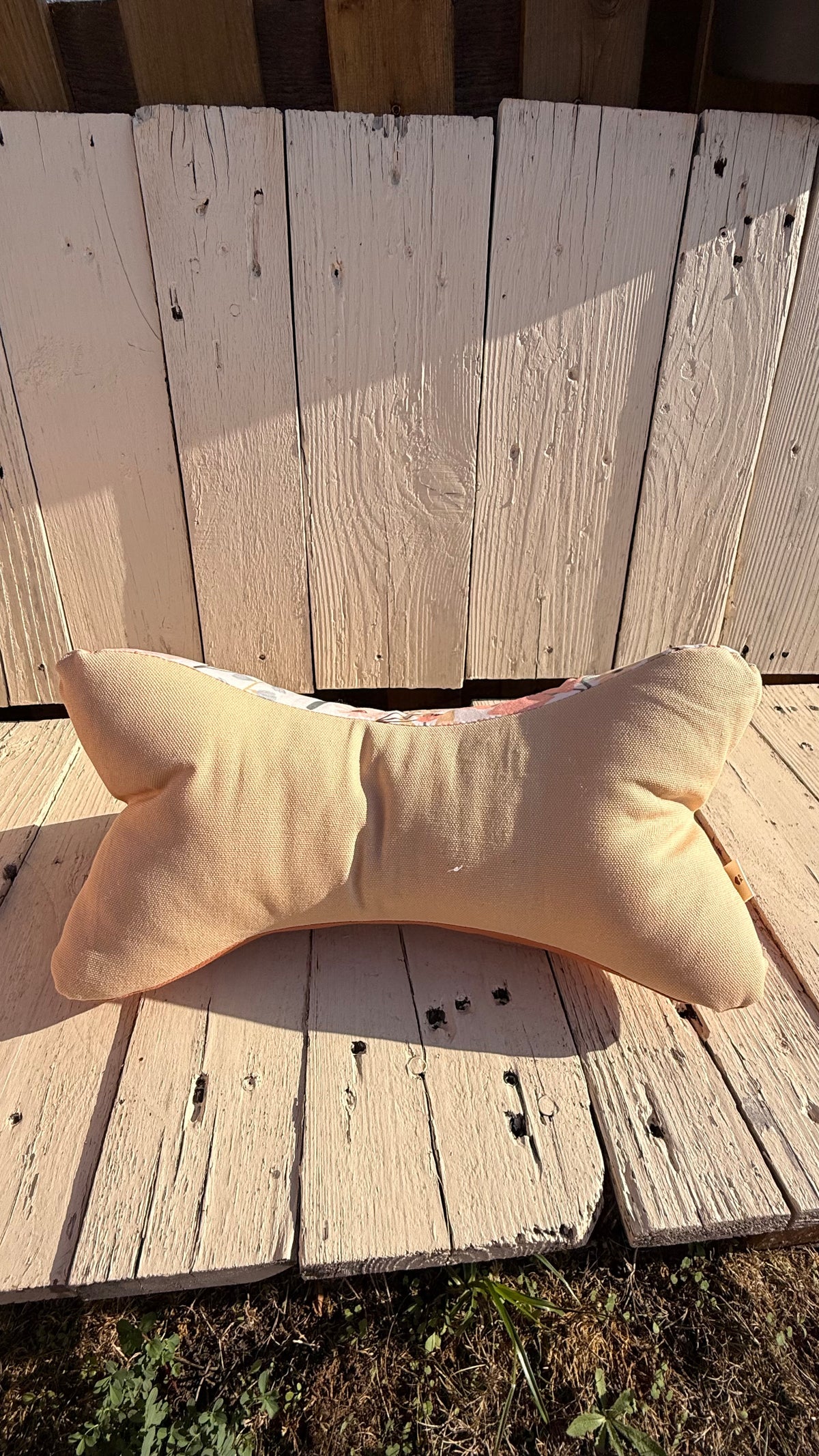 Handgefertigter Leseknochen als Nackenkissen, heller Stoff mit zarten peach- und korallfarbenen Blumen und Blättern, kombiniert mit einfarbig terracottafarbenem Stoff, aus Dein Krämerladen.