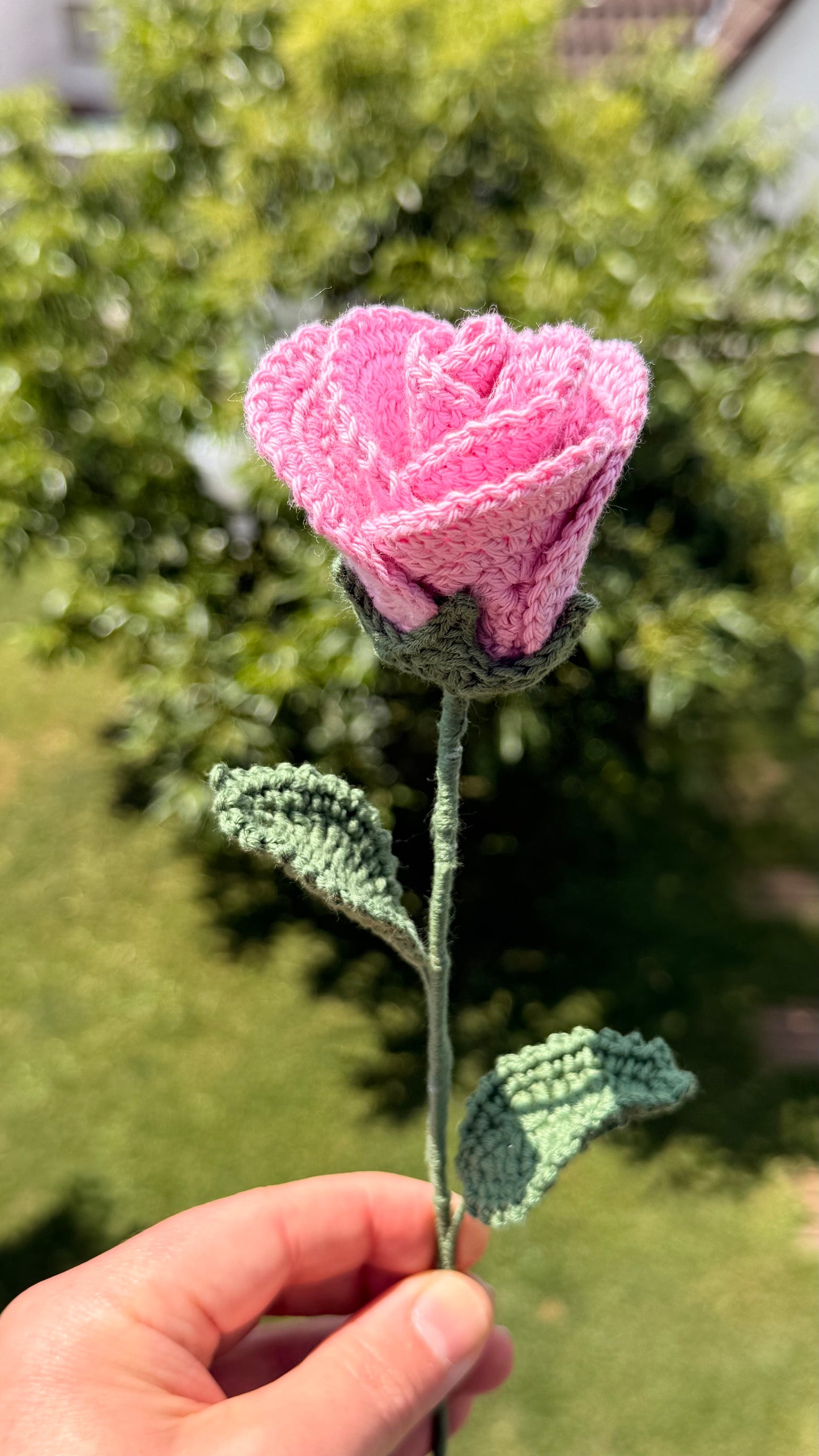 Handgehäkelte rosa Rose mit grünen Blättern, handgefertigtes botanisches Unikat von Edeltrud, langlebige Dekoration aus Baumwolle.