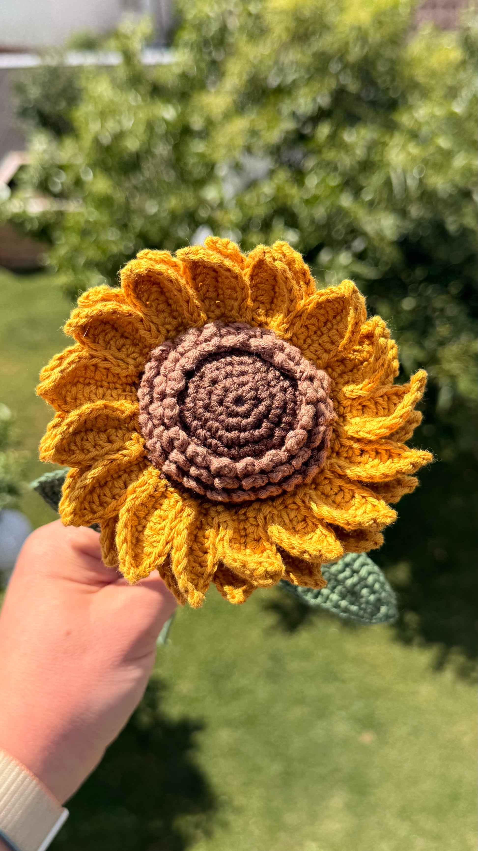 Detailaufnahme einer handgehäkelten Sonnenblume, hochwertige Häkelkunst als nachhaltiges Geschenk, handgemacht im Krämerladen-Stil.