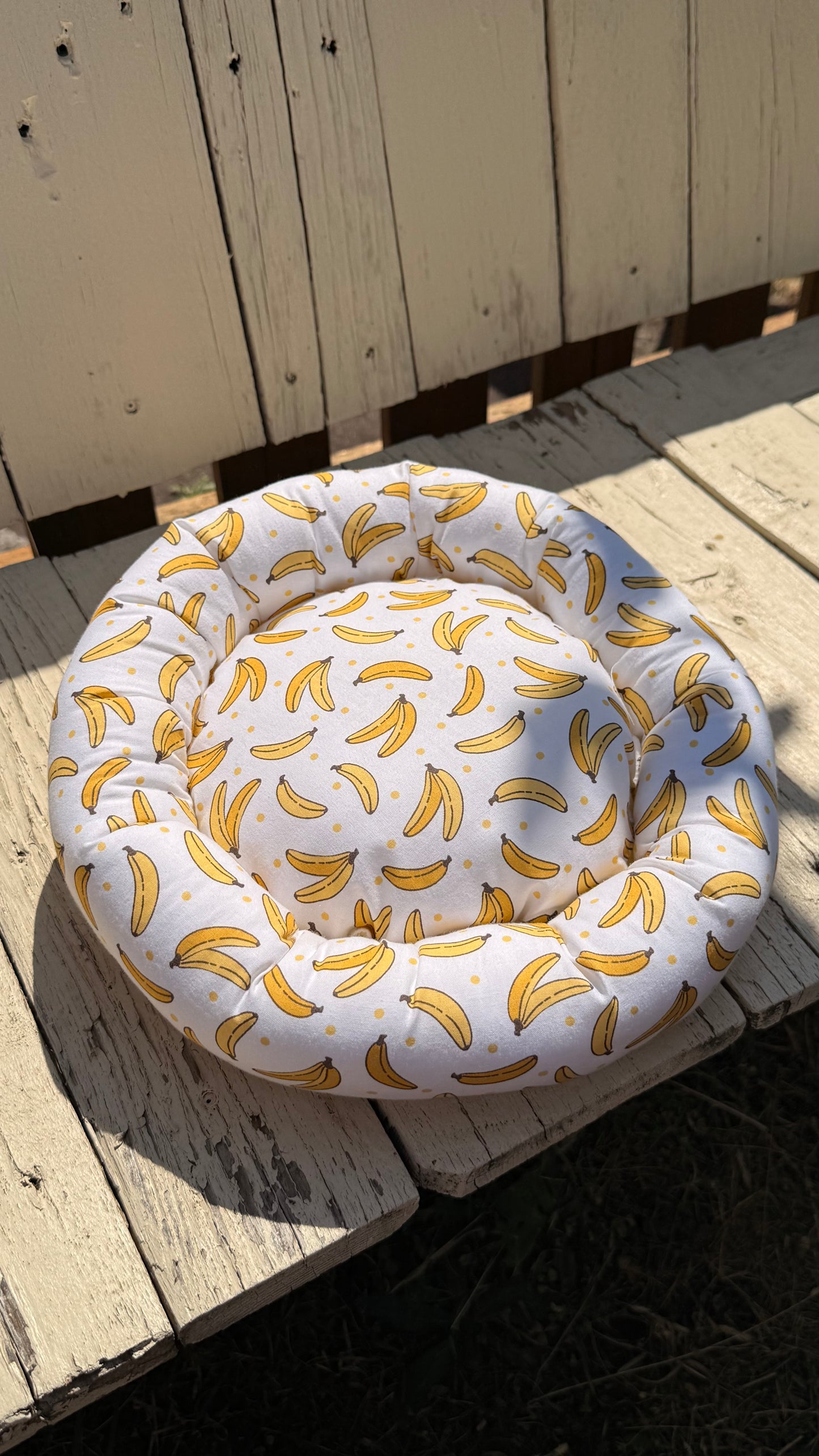 Handgefertigter Kuscheldonut für Meerschweinchen, heller Stoff mit gelbem Bananen-Muster und Punkten, weiches und gemütliches Kleintierbett aus Dein Krämerladen.
