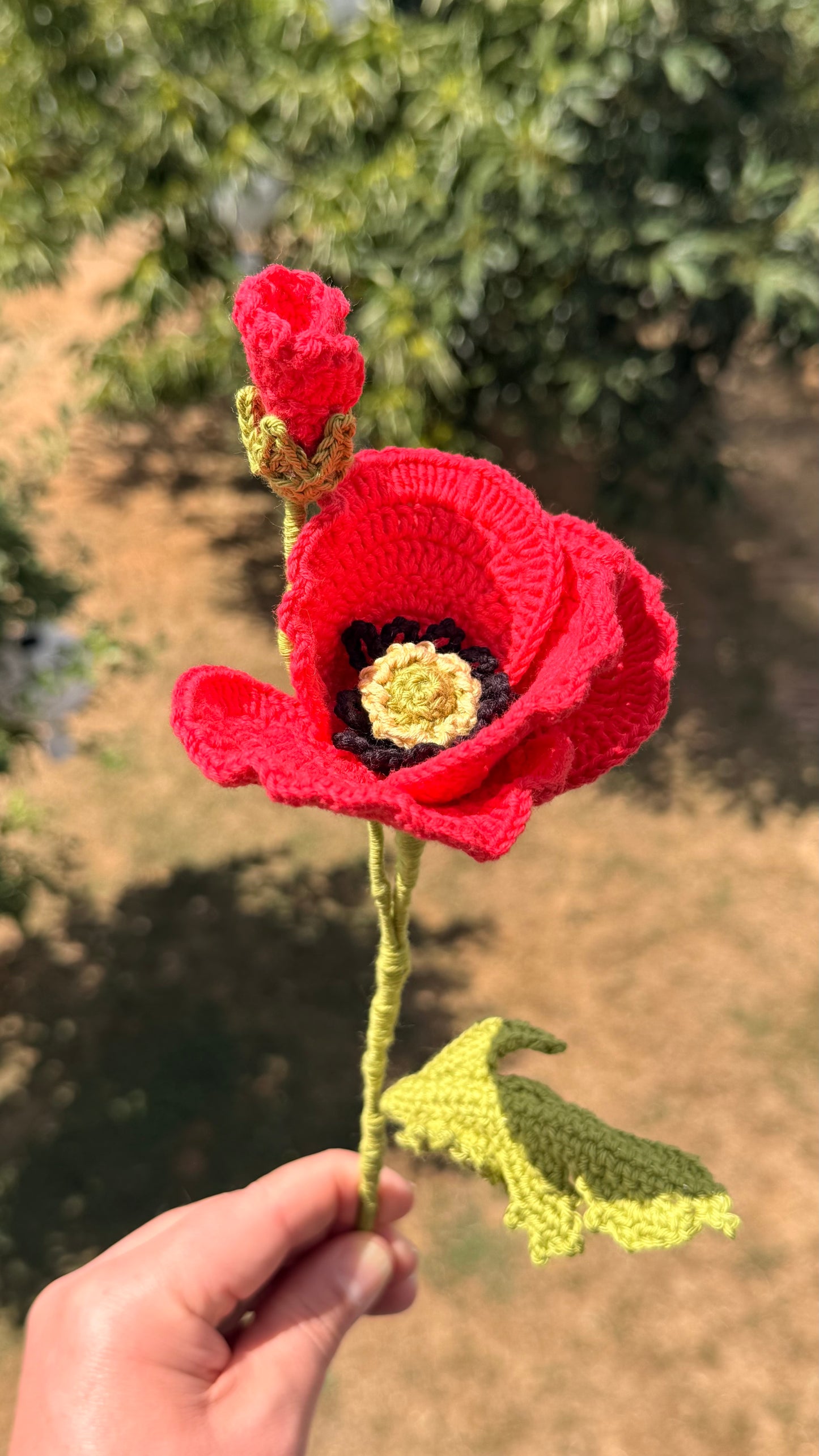 Handgehäkelte rote Mohnblume mit offener Blüte, einer geschlossenen Knospe und grünem Stiel mit Blättern, handgemachte Häkelblume aus Dein Krämerladen.