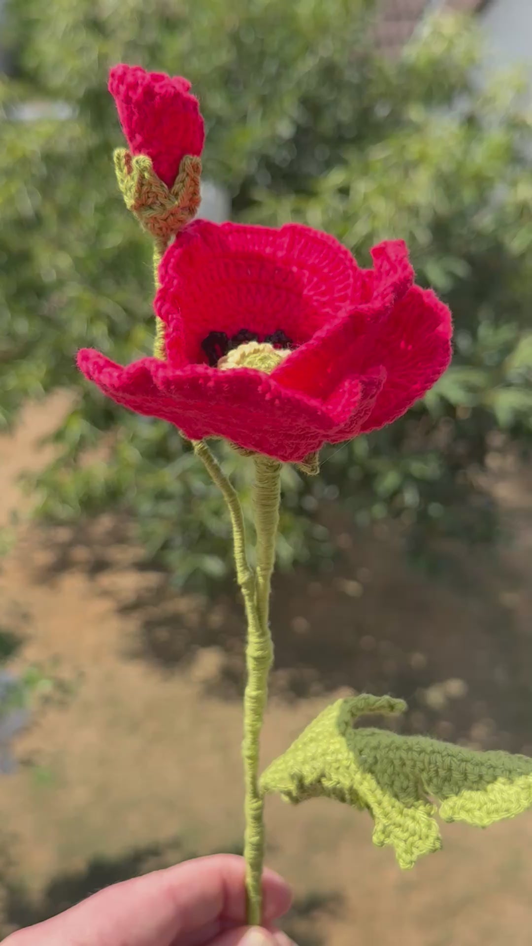Handgehäkelte rote Mohnblume mit offener Blüte, einer geschlossenen Knospe und grünem Stiel mit Blättern, handgemachte Häkelblume aus Dein Krämerladen.